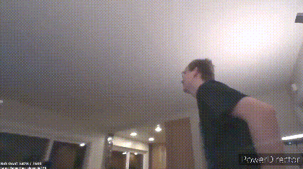 a man in a black shirt is standing in a room with a power director watermark in the corner .