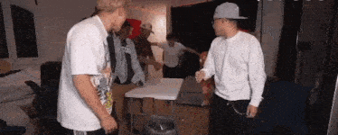 a group of young men are standing around a table .