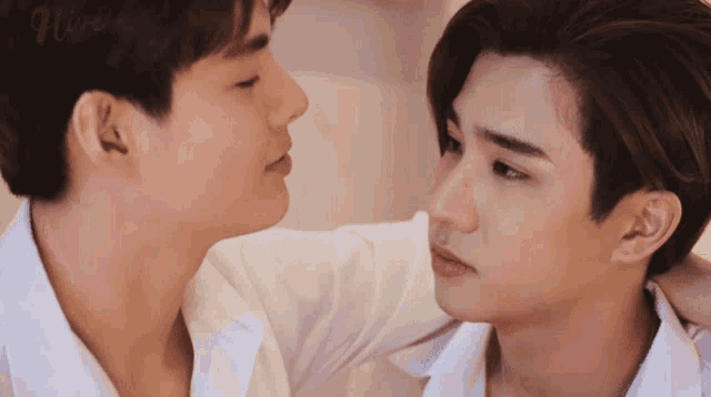 a couple of men are looking at each other and the word love is on the bottom right