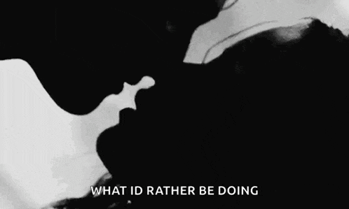 a man and a woman are kissing in a black and white photo with the words `` what id rather be doing '' .