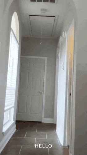 a hallway with a ceiling fan and a door that says hello on it
