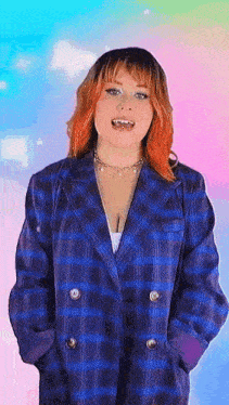 a woman with red hair is wearing a blue plaid jacket and necklace .