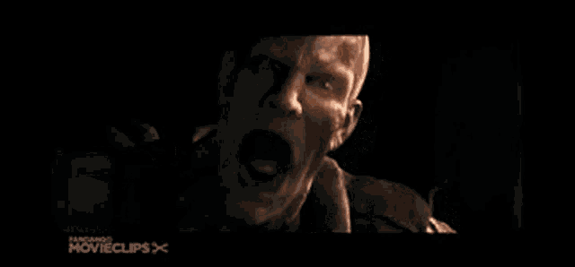 a close up of a man 's face in a dark room with smoke coming out of his eyes .