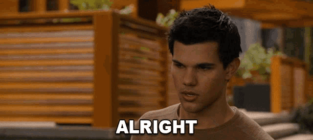 a man in a brown shirt says " alright "