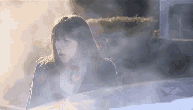 a woman is standing in a foggy area with a car behind her
