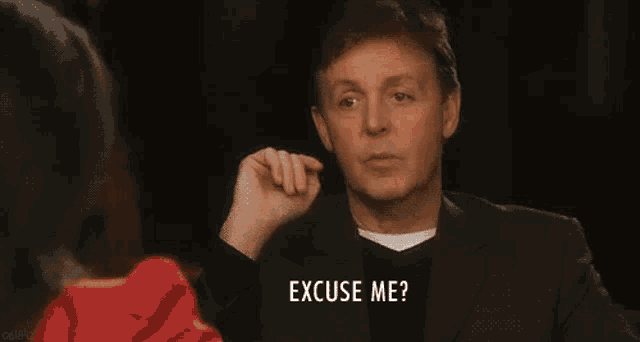 a man in a suit is asking a woman to excuse him