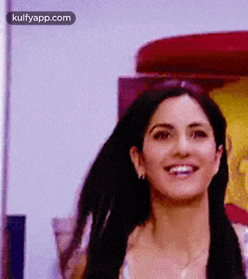 a close up of a woman 's face with long black hair smiling .