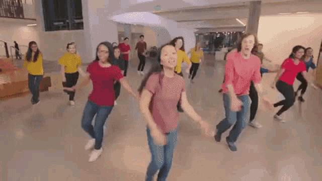 a group of young people are dancing in a hallway