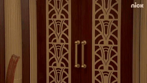 a man in a superhero costume is standing in a doorway with his arms outstretched .
