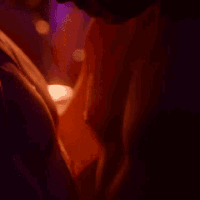 a man and a woman are kissing in a dark room in a close up of their bodies .