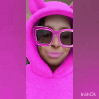 a girl wearing a pink hoodie and sunglasses blowing a pink bubble gum