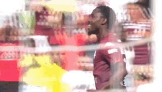 a blurry picture of a man in a red shirt standing in front of a store .