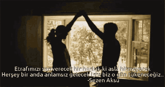 a man and a woman are dancing in front of a window