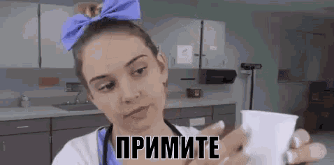 a woman with a blue bow on her head is holding a cup with the word " primite " on it .