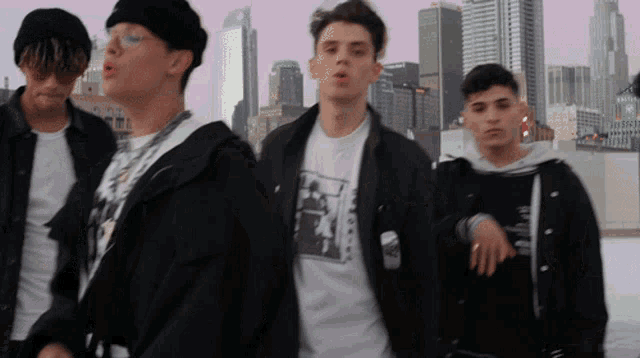 a group of young men standing in front of a city