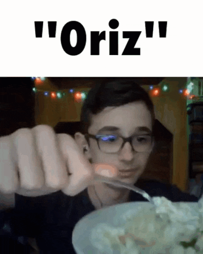 a young boy with glasses is eating a bowl of food with a fork .