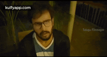 a man with glasses and a beard is shown in a telugu film