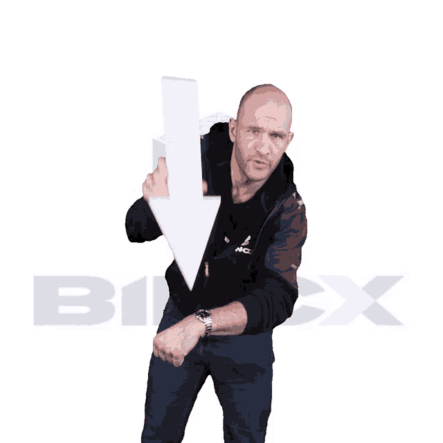 a man in a black jacket holds a white arrow pointing down