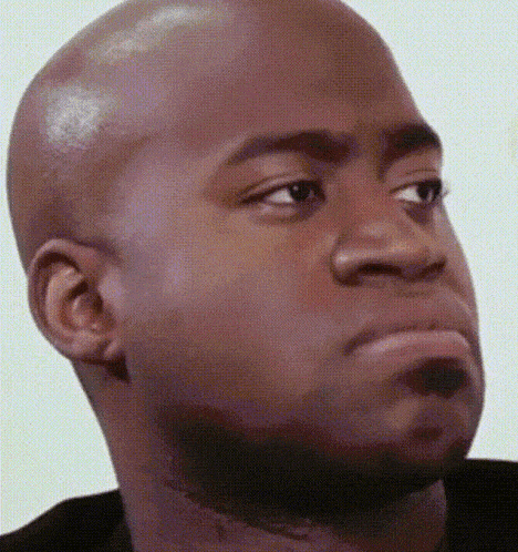 a bald man with a beard is making a funny face while looking at the camera .