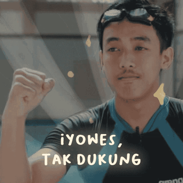 a man wearing swimming goggles and a shirt that says ayomes tak dukung