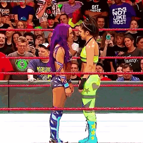 two female wrestlers are facing each other in a wrestling ring