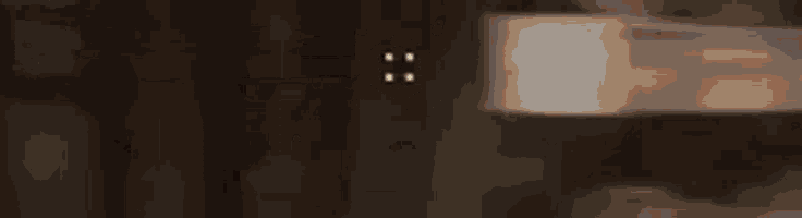 a blurred image of a light bulb hanging from a wall .