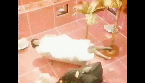 a woman is laying in a bathtub covered in foam .