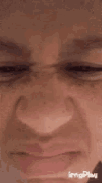 a close up of a person making a funny face with their eyes closed .