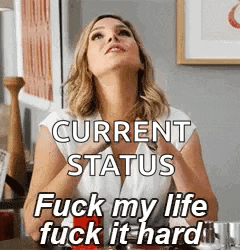 a woman is sitting at a table with her hands on her chest and saying `` current status fuck my life fuck it hard `` .