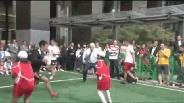 a group of people are playing soccer in front of a crowd .