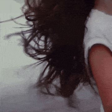 a close up of a woman 's hair with a white shirt on