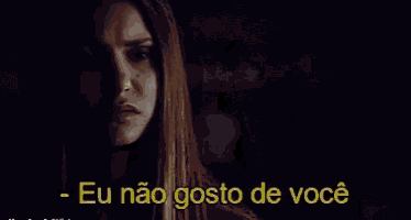 a woman in a dark room with the words eu nao gosto de você written in yellow
