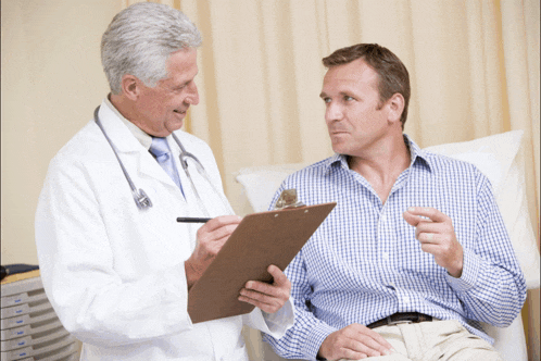 a doctor is talking to a patient who is sitting in a hospital bed