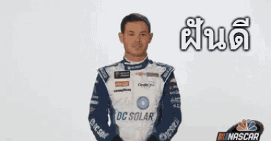 a man in a nascar uniform is giving a thumbs up sign