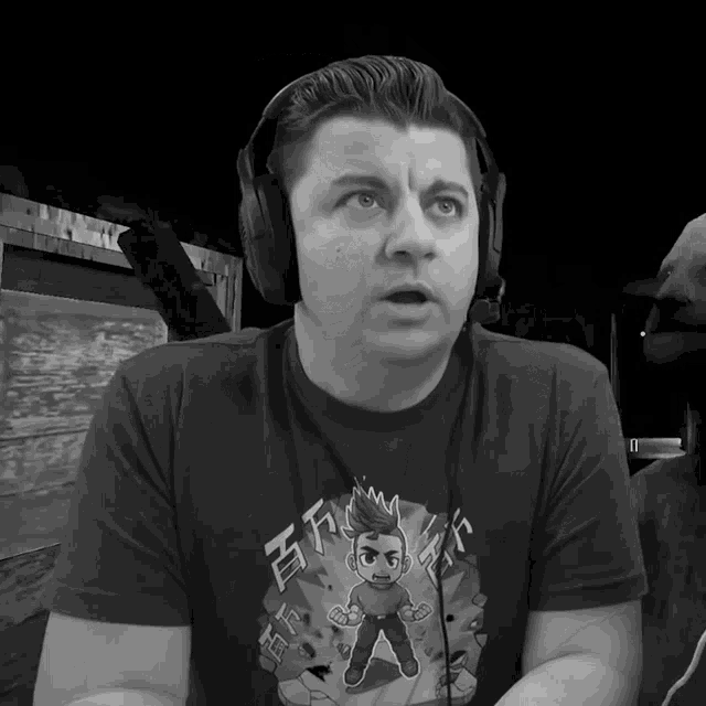 a man wearing headphones and a t-shirt with a cartoon character and chinese writing on it