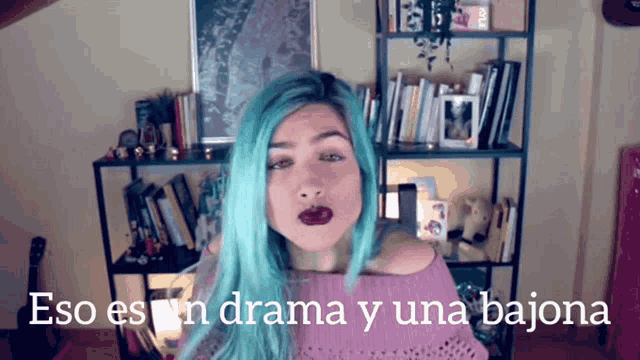 a woman with blue hair is standing in front of a bookshelf with the words " eso es un drama y una bajona " below her
