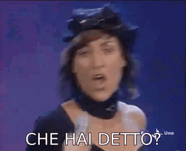a woman is singing into a microphone with the words `` che hai detto '' written on it .