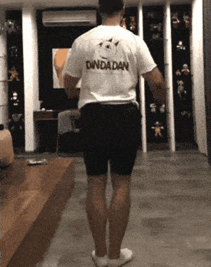 a man wearing a shirt that says danda dan on the back