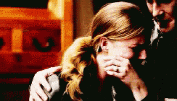 a man is comforting a woman who is crying and covering her face with her hands