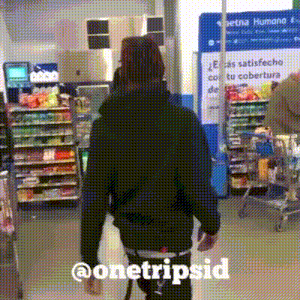 a man in a black jacket is walking through a store with the words @onetripsid written on the bottom