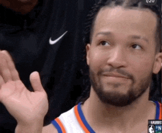 a basketball player wearing a nike shirt is waving his hand