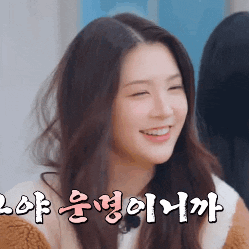 a woman with korean writing on her face smiles with her eyes closed