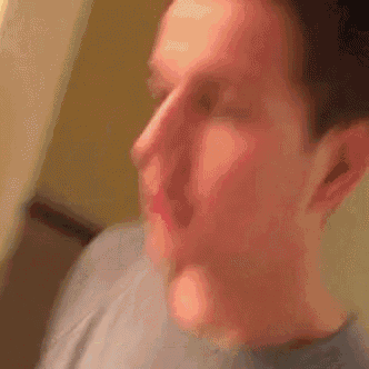 a close up of a man 's face in a grey shirt .