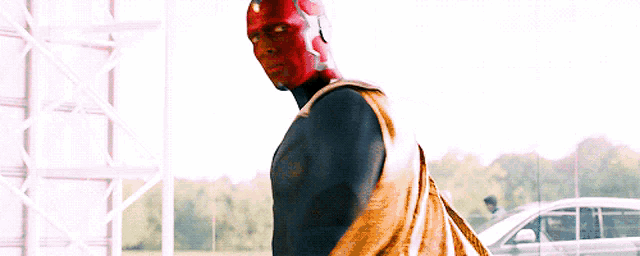 a man in a superhero costume is standing in front of a car