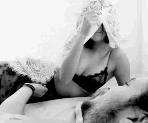 a black and white photo of a woman covering a man 's eyes