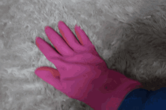 a person wearing a pink rubber glove with a 3m logo on it