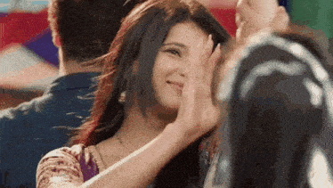 a woman is covering her face with her hand while a man looks on .