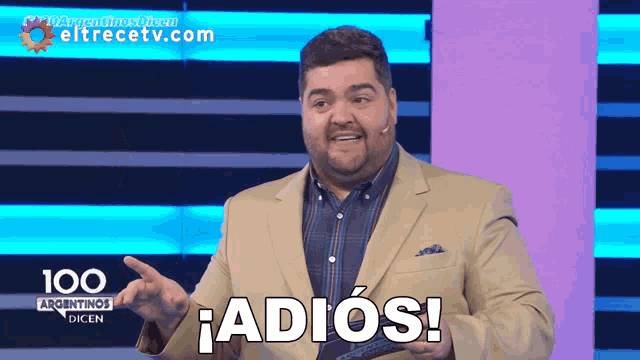 a man in a suit says adios in front of a 100 argentinas dicen sign