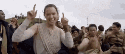 a woman is giving a thumbs up sign in front of a crowd .