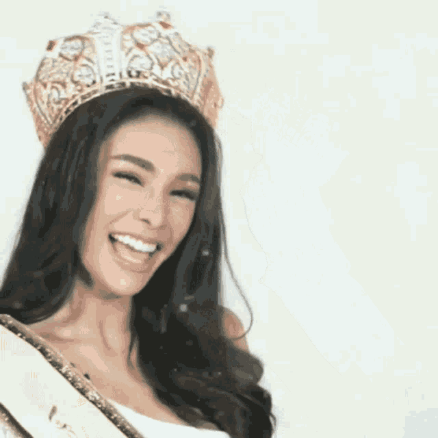 a woman is wearing a crown and smiling .